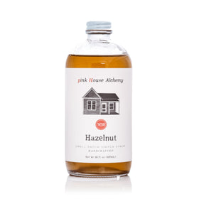 Pink House Alchemy Hazelnut Simple Syrup bottle pour enhances coffee and cocktails.
