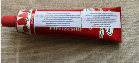 Piros Arany Univer paprika paste hot Csipos on spoon, ready to elevate sauces and stews.