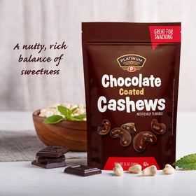 Close-up of Platinum Chocolate Coated Cashews shows creamy milk chocolate on roasted cashews.