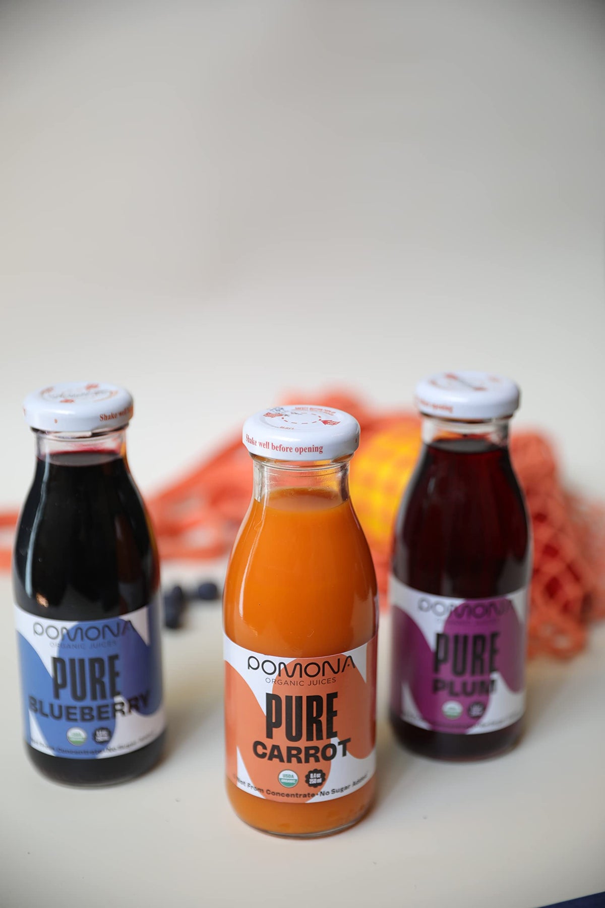 Pomona Organic Juices glass bottle 12-pack promotes eco-friendly packaging for on-the-go refreshment.