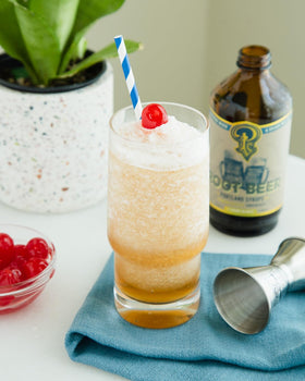 Pouring Portland Syrups Genuine Root Beer Syrup over a glass
