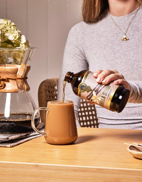 Portland Syrups Vanilla Syrup bottle beside a cocktail for versatile use.