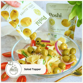 POSHI Green Olives Basil & Garlic on a charcuterie board.
