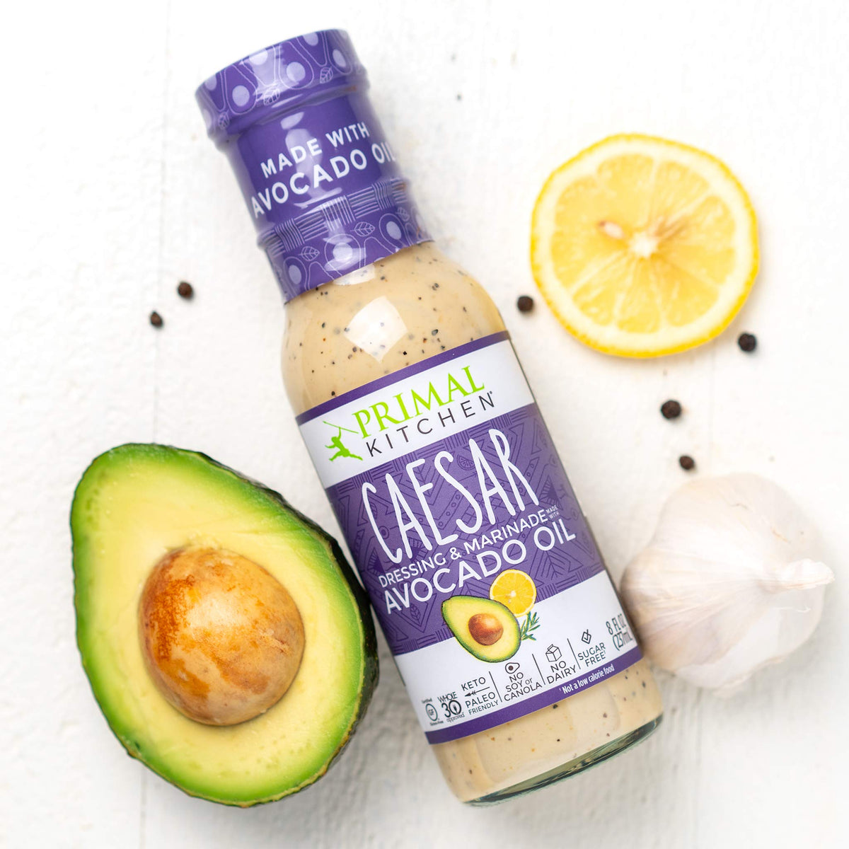 Primal Kitchen Caesar dressing bottle pour, tangy flavor for protein bowls and cauli rice.