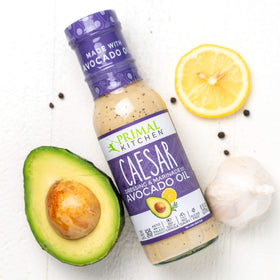 Primal Kitchen Caesar dressing bottle pour, tangy flavor for protein bowls and cauli rice.