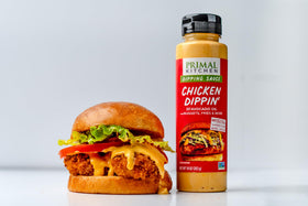 Primal Kitchen Yum Yum bottle beside skewers highlights grilling-friendly dip.