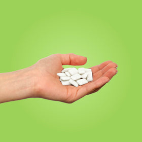 Closeup of PUR Gum Coolmint pieces, xylitol-sweetened breath freshener.