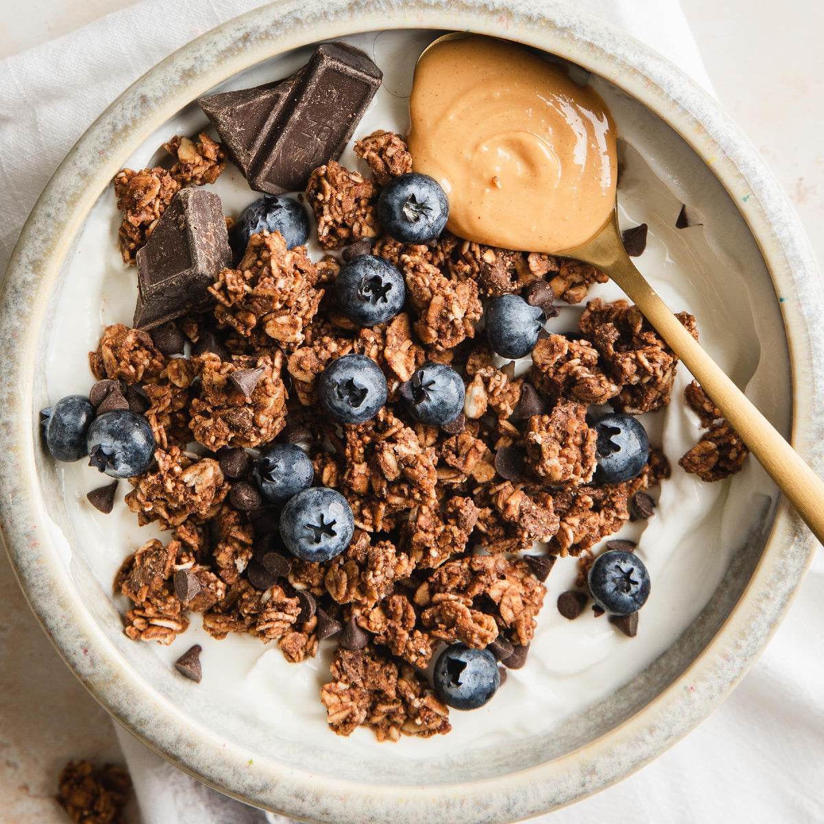 Purely Elizabeth granola in bowl with milk and berries