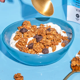 Granola poured over yogurt highlighting versatile serving option.