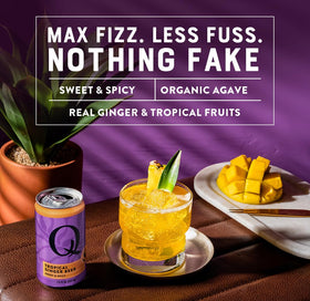 Glass of Q Tropical Ginger Beer with citrus wedges for a lively cocktail base.