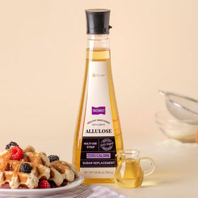 Pouring q.one Trusweet allulose syrup over pancakes for a sugar-free drizzle
