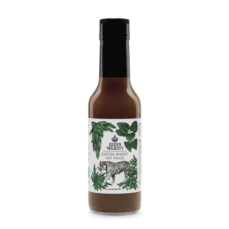 Queen Majesty Cocoa Ghost Hot Sauce bottle on a kitchen counter, previewing a bold chocolate-pepper flavor.