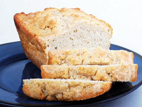 Rabbit Creek beer bread loaf being sliced, warm and inviting for a snack.