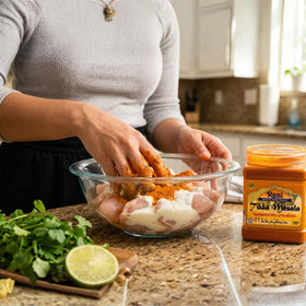 Pouring Rani Tikka Masala spice blend adds bold flavor to marinades.