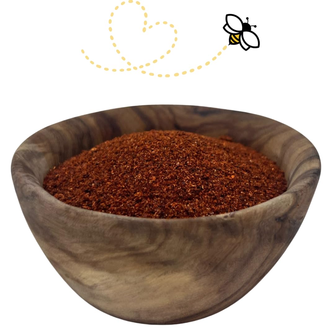 Raw Essentials New Mexico Red Chili Powder pouring from the jar into a spoon for depth and aroma.