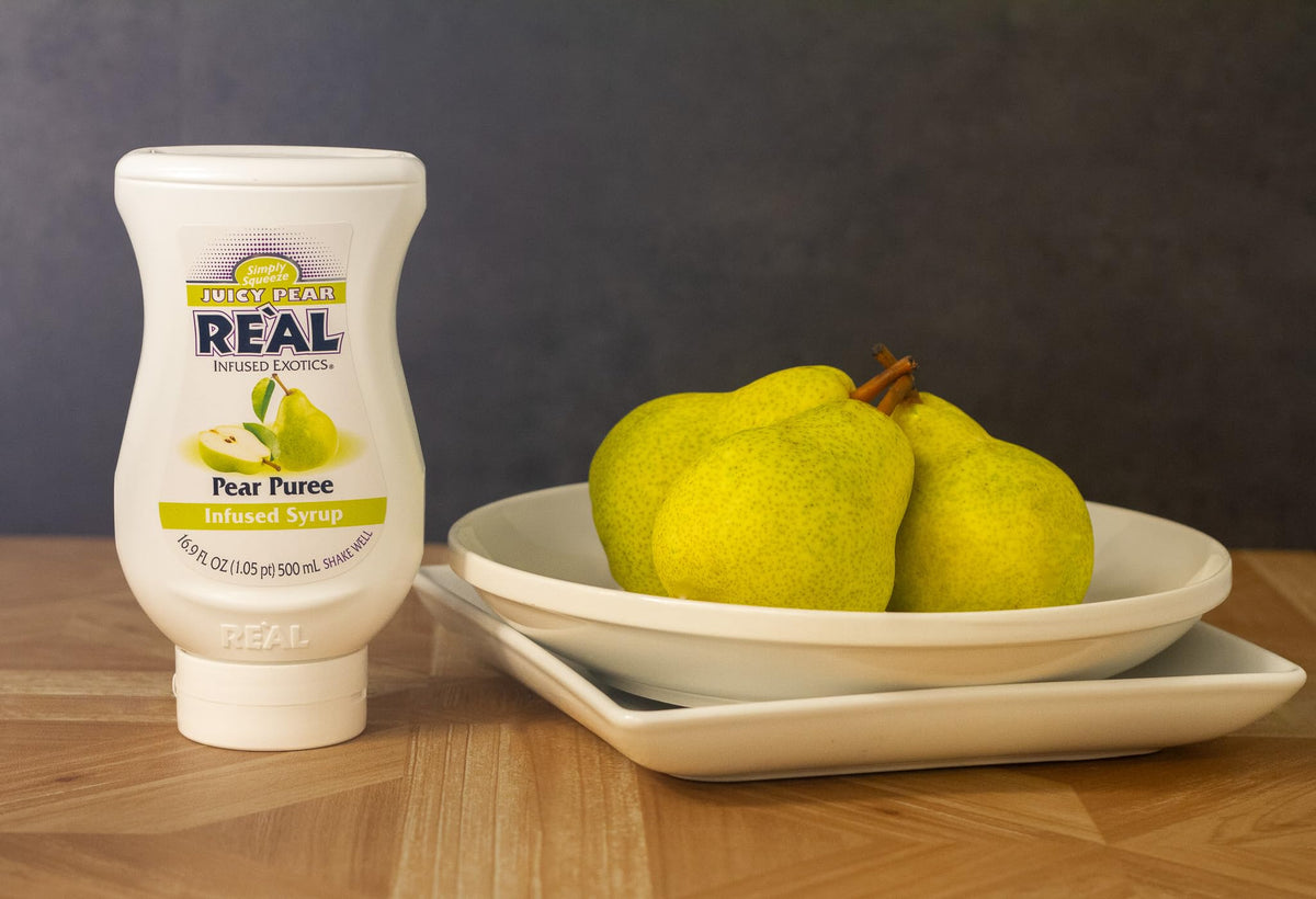 Close-up of Reàl Infused Exotics Juicy Pear syrup pouring for easy drink customization.