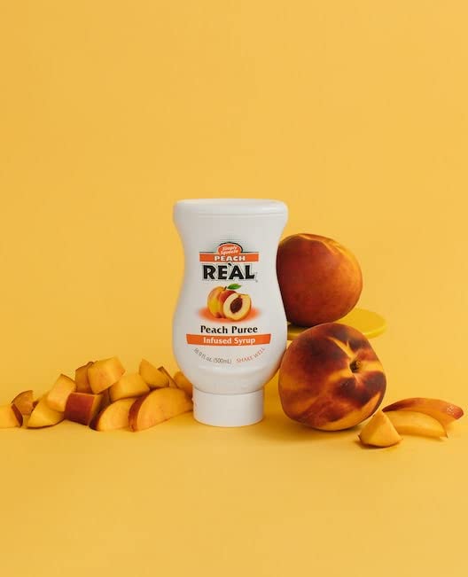  Peach Puree Syrup from Real Infused Exotics poured into a glass for a refreshing drink