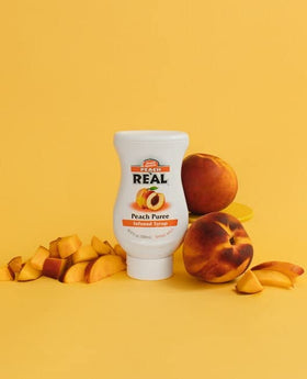  Peach Puree Syrup from Real Infused Exotics poured into a glass for a refreshing drink