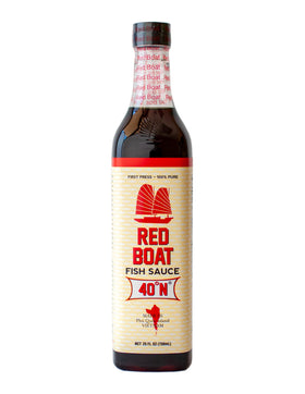 Red Boat fish sauce bottle on kitchen counter for rich umami in sauces.