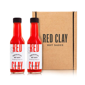 Red Clay Original Hot Sauce two-bottle set front view for versatile seafood and eggs seasoning.