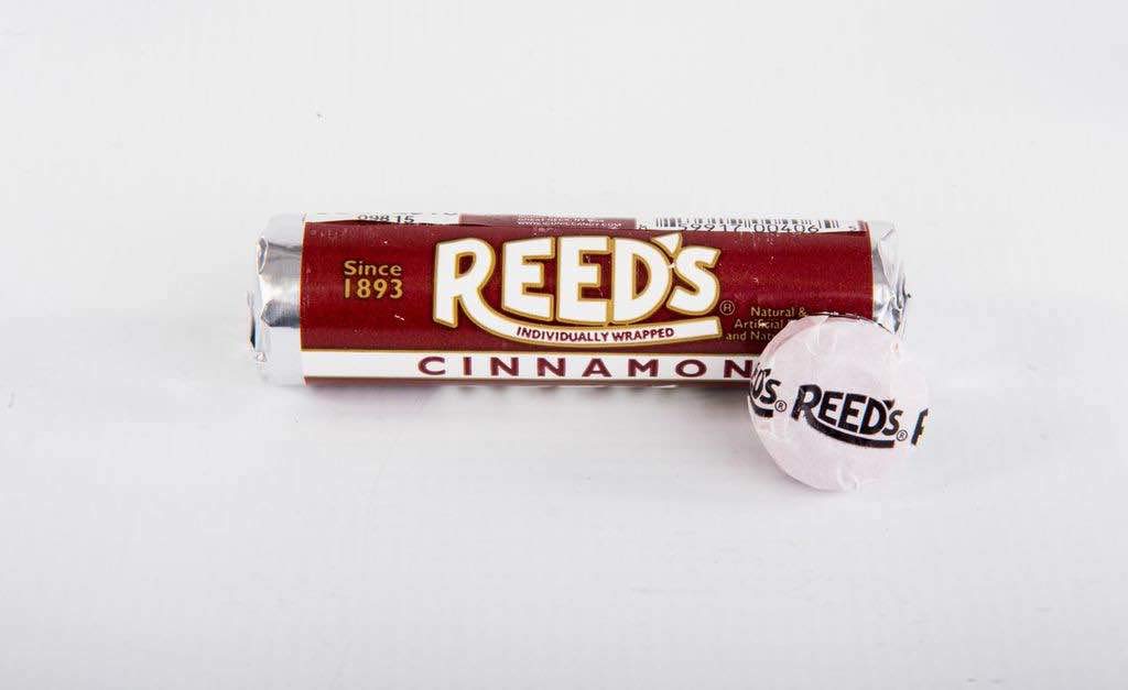 Close-up of Reed’s Root Beer Candy Rolls wrappers highlighting the Reed’s logo.
