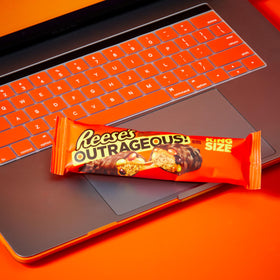 Cross-section view of Reese's Outrageous bar showing peanut butter, caramel, and PIECES.