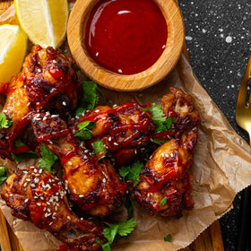 Rex Sriracha being poured enhances marinades and toppings.
