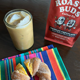 Kitchen scene with cinnamon sticks beside Roasty Buds Mexican Chocolate beans.