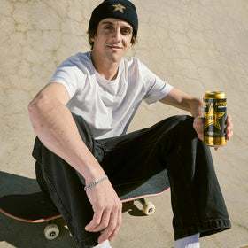 Athlete on the go reaching for Rockstar Original Energy to power training.
