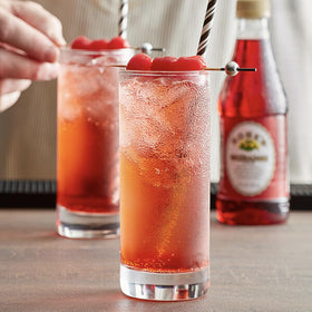 Rose’s Grenadine bottle on the bar shows balanced sweetness for modern drinks.