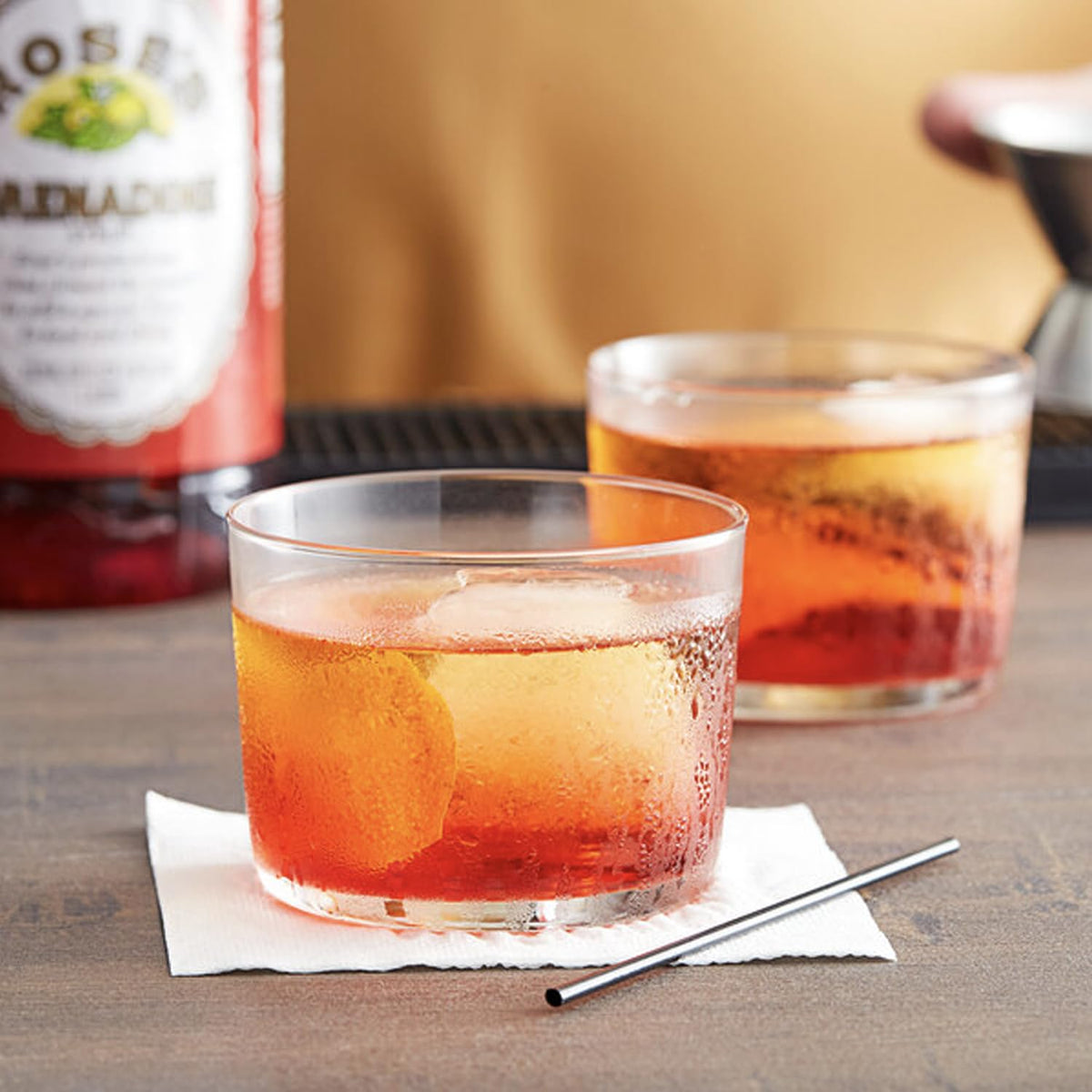 Rose’s Grenadine color and bottle in a vibrant cocktail setup for layering.