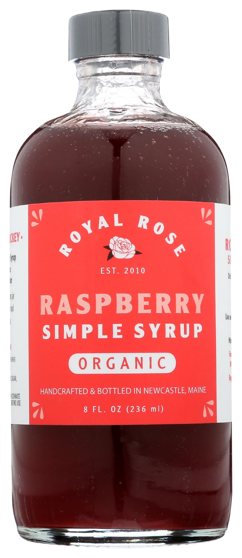 Royal Rose Organic Raspberry Simple Syrup bottle on counter, ideal for cocktails and toppings.
