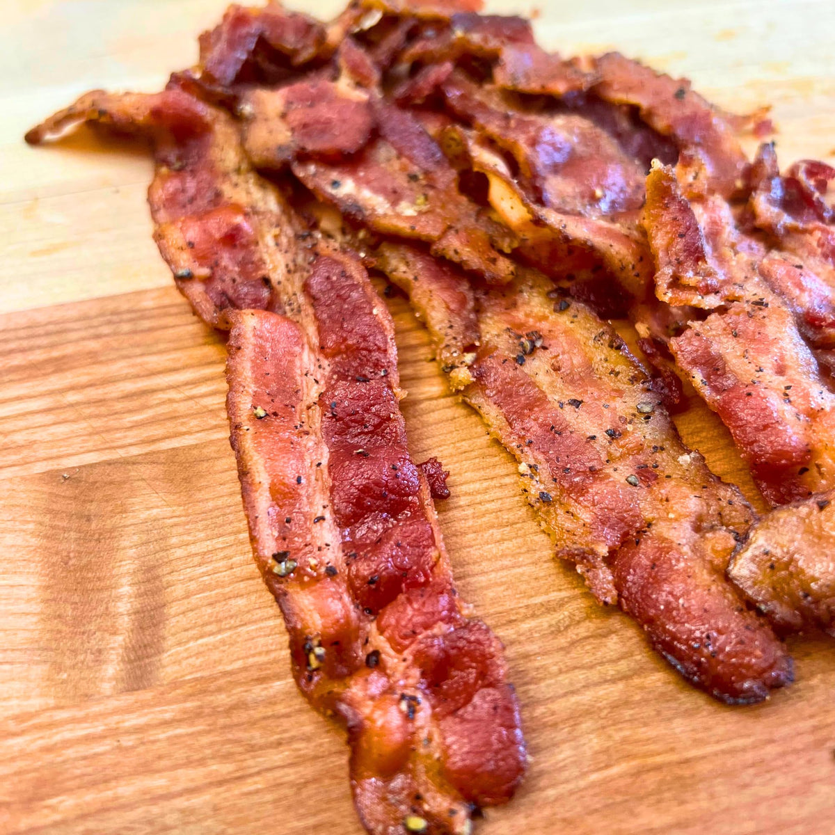 RunninWild Bacon Jerky serving plate styled image suggests gourmet snack for on-the-go.