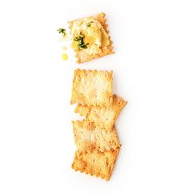 Rustic Bakery crackers on a cheese plate, ideal for soft and hard cheeses.