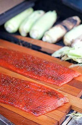 Salmon on grill with Rub with Love rub emitting smoky aroma