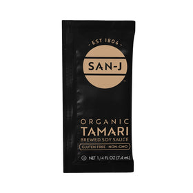 Pouring a San-J Tamari packet to enhance stir-fries with authentic depth.