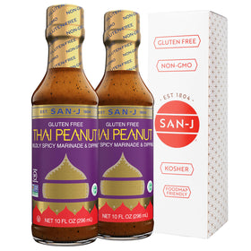 San-J gluten-free Thai Peanut Sauce bottle pour showcases gluten-free, versatile flavor for marinades.
