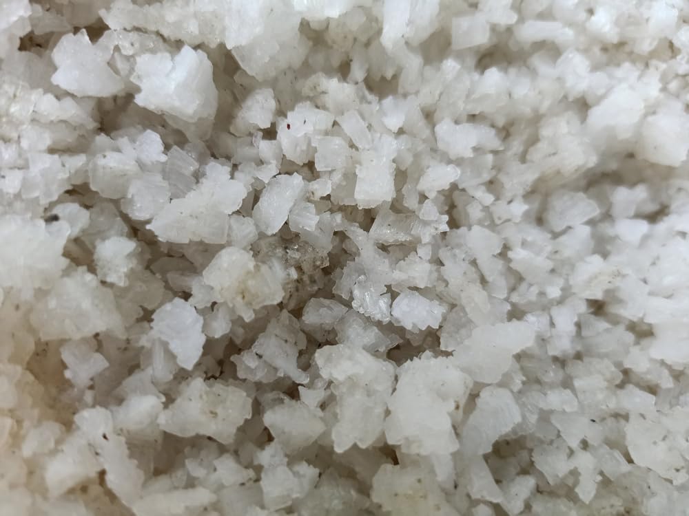 Sanniti coarse grey salt being poured over a dish.