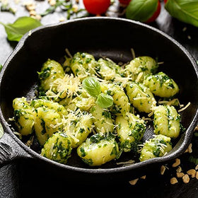 Sanniti cooking gnocchi dish sizzling in skillet.