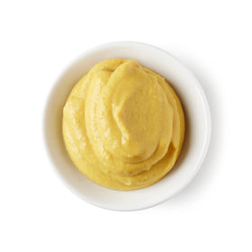 Sanniti Dijon Mustard paired with a sandwich on a plate