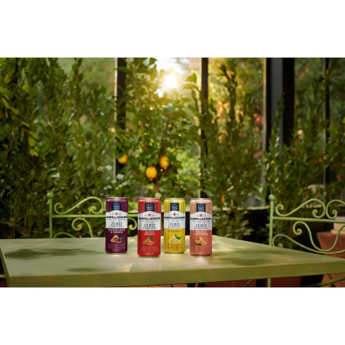 Sanpellegrino Zero Sugar Pomegranate Orange cans on a picnic blanket, portable flavor