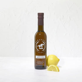 Saratoga Olive Oil Co. Sicilian Lemon White Balsamic bottle on a kitchen counter for bright dressings.