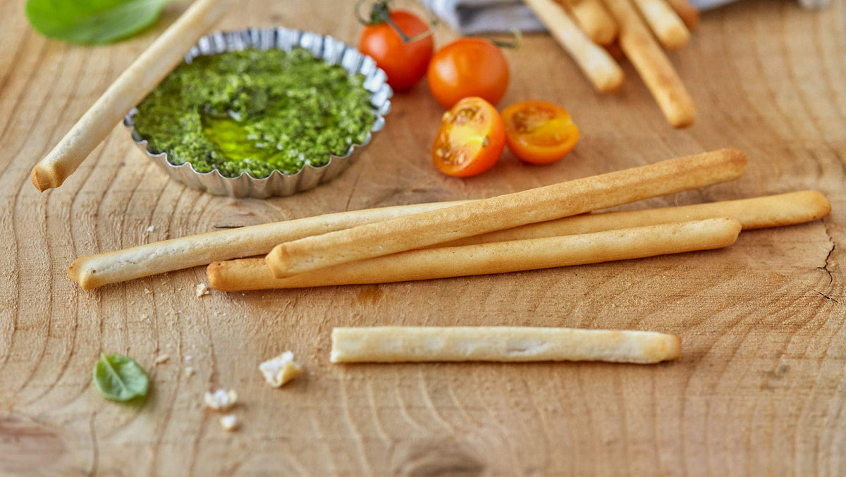Schär gluten-free breadsticks dipping olive oil for flavorful starters.