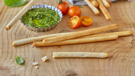 Schär gluten-free breadsticks dipping olive oil for flavorful starters.