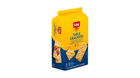 Schar Original Table Crackers on a picnic table, perfect gluten-free snack.