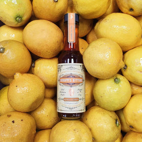 Scrappy's Black Lemon ingredients shown with fresh zests and herbs.