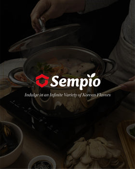 Sempio Jin S stir-fry pan with sauce pouring over vegetables.