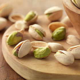 Setton Farms pistachios close-up with cracked shells and bright green kernels.