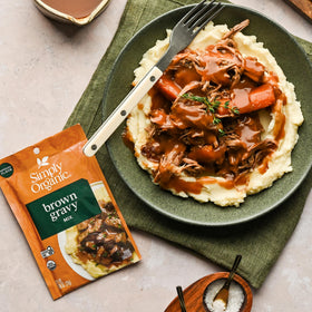 12-pack box of Simply Organic Brown Gravy Mix on store shelf.