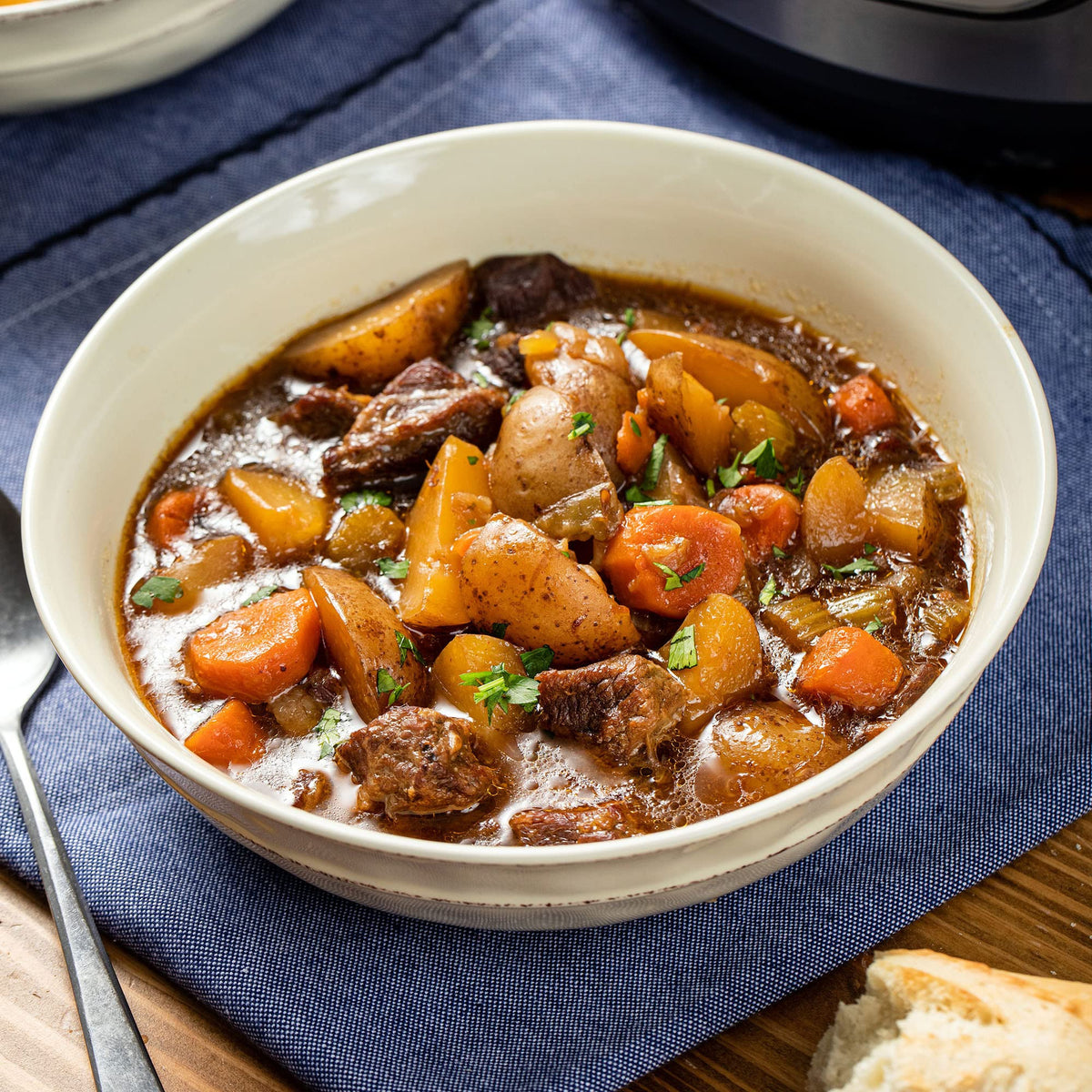 Slow cooker simmering beef stew, aroma filling kitchen with McCormick flavor.